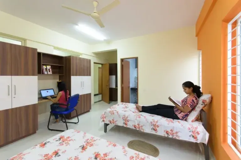 A girls’ hostel room with a study corner