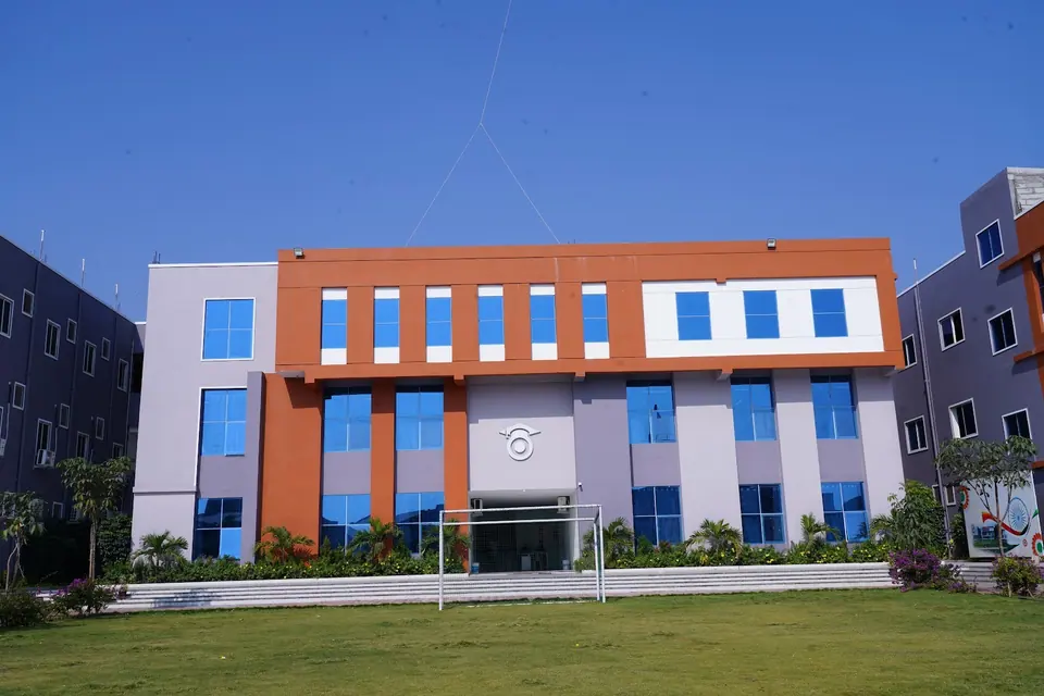 The academic block behind a wide green lawn