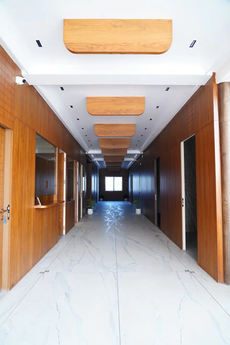 A bright corridor with marble floors and wooden panelling