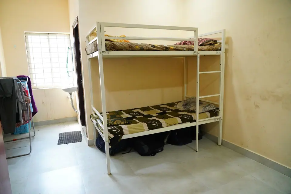 A bright hostel room with a bunk bed