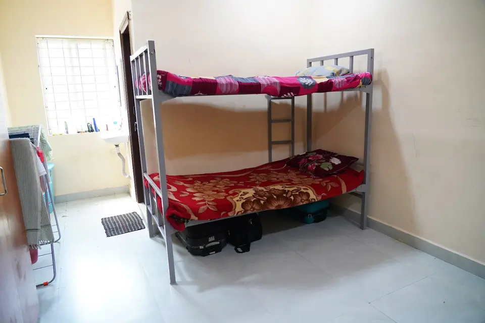 A hostel room with a bunk bed and attached bathroom