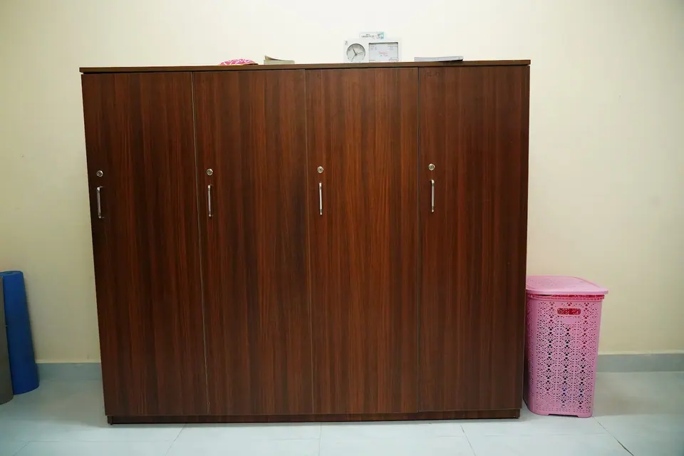 A large wooden wardrobe in a hostel room