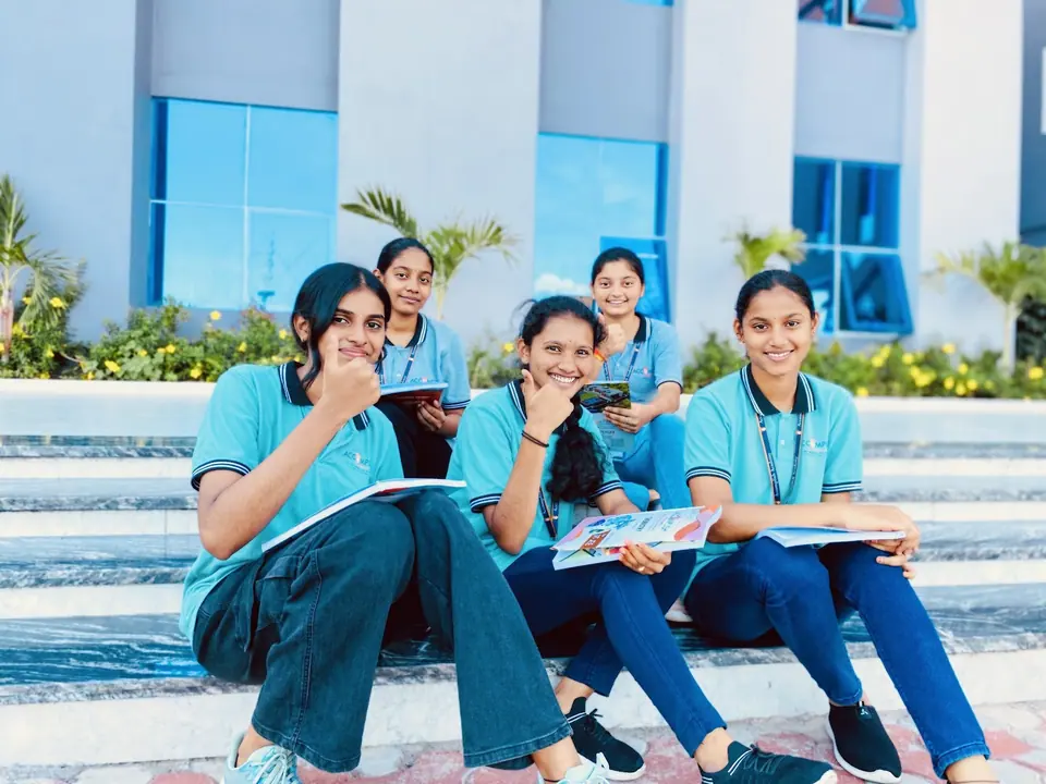 Students reviewing notes on the steps outside the main block