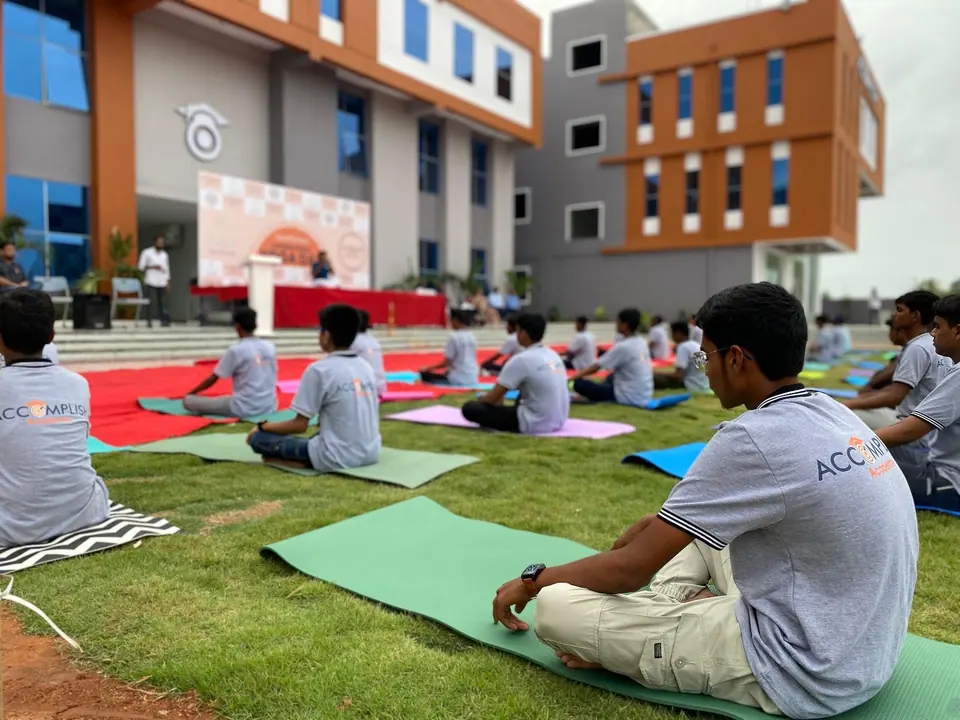 Students practising yoga on the lawn on International Yoga Day